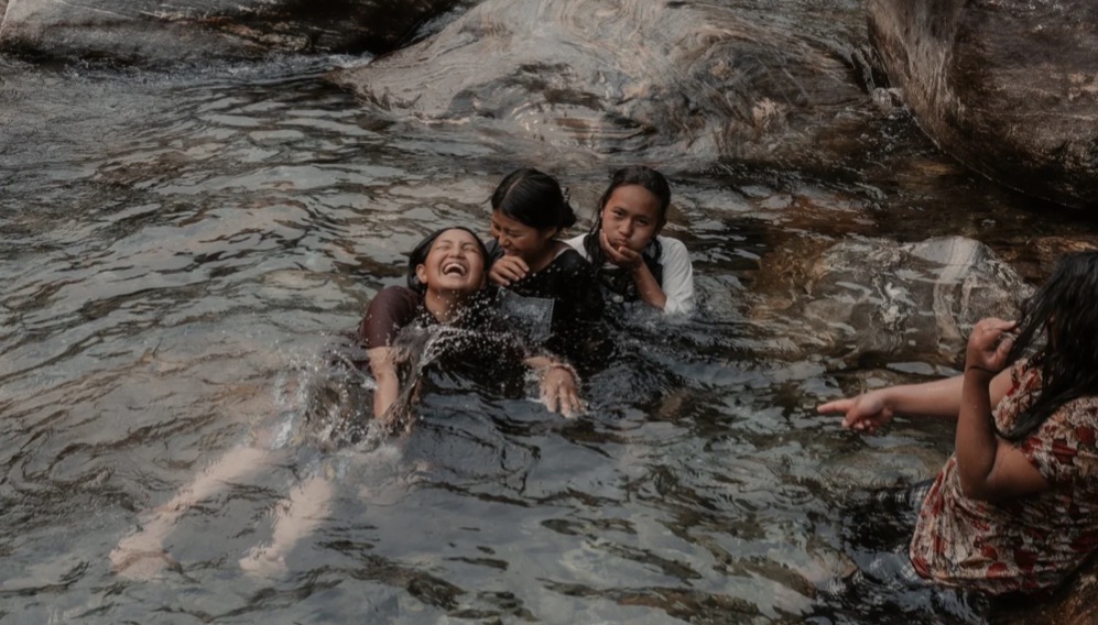 Girls laughing and playing in a mountain river